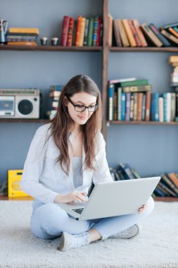 oturma odasında yere üstünde laptop ile mutlu bir kadın
