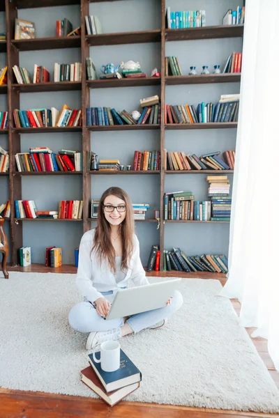 Счастливая женщина с ноутбуком на полу гостиной — стоковое фото