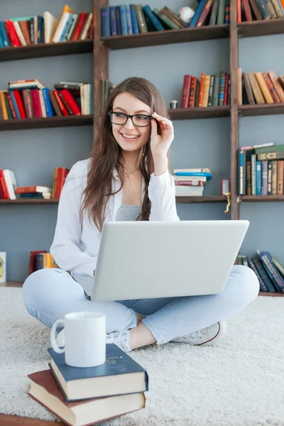 Mujer feliz con portátil en el piso de la sala de estar — Foto de Stock