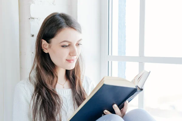Chica leyendo libro en la ventana — Foto de Stock
