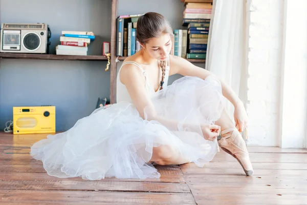 Танцовщица балета обвязывает тапочки вокруг лодыжки балерины Пуанте — стоковое фото