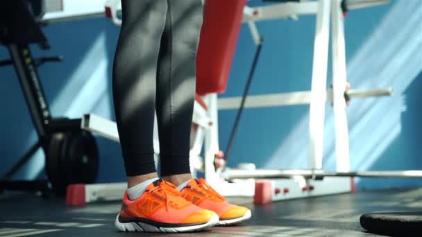 Mujer joven haciendo ejercicios sobre el aparato de entrenamiento en el gimnasio 20s. 1080p cámara lenta — Vídeos de Stock