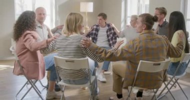 Grup terapisi sırasında el ele tutuşan gençler. Birbirinden Destek Duymak