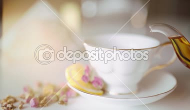 limon ve gül ile güzel bir beyaz fincan çay dökün