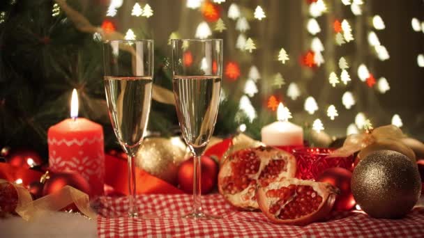 Twee glazen van champagne met kerstcadeau en kerstballen — Stockvideo