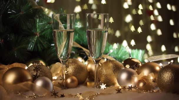 Two glasses of champagne with christmas present and christmas balls — Stock Video