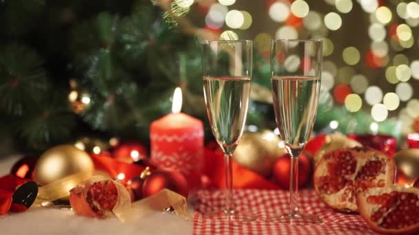 Dos copas de champán con regalo de Navidad y bolas de Navidad — Vídeos de Stock