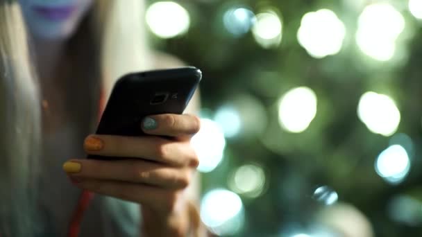 Female hand is holding a modern touch screen phone and  blurred image — Stock Video