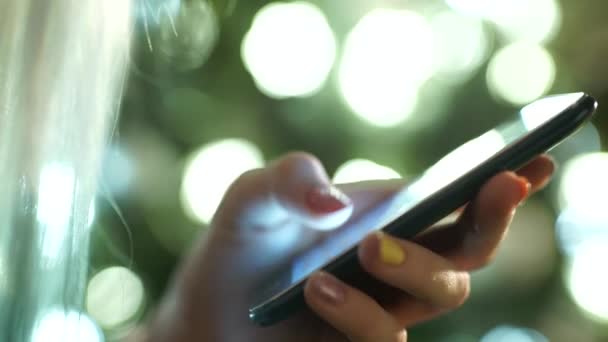 Main féminine tient un téléphone à écran tactile et une image floue — Video