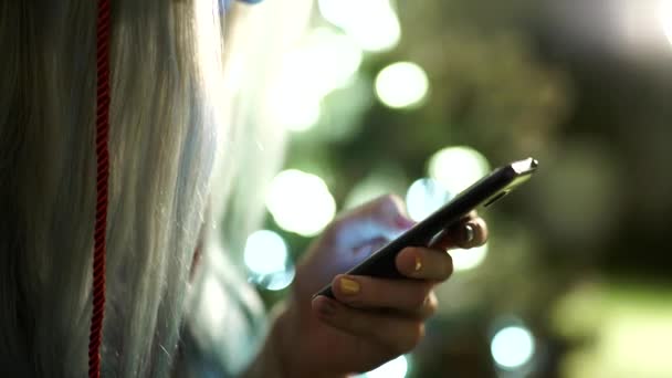 main féminine tient un téléphone à écran tactile moderne et une image floue 