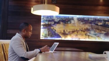 Dizüstü bilgisayar kullanan yakışıklı siyah adam