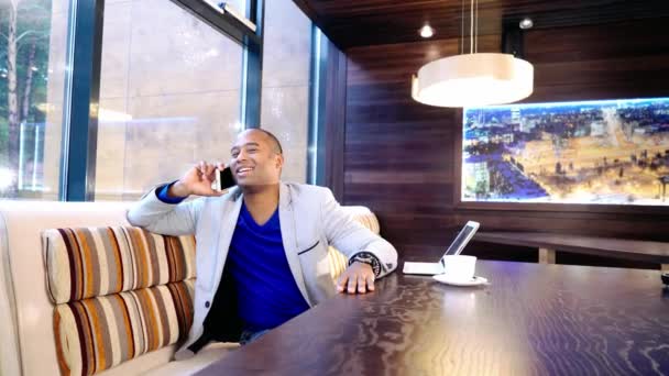 Empresário sentado relaxado no sofá no lobby do hotel fazendo um telefonema — Vídeo de Stock