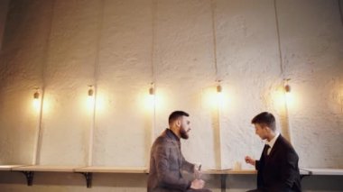 Cafe'de oturan iki adam mutlu doğal ışık gülümse.