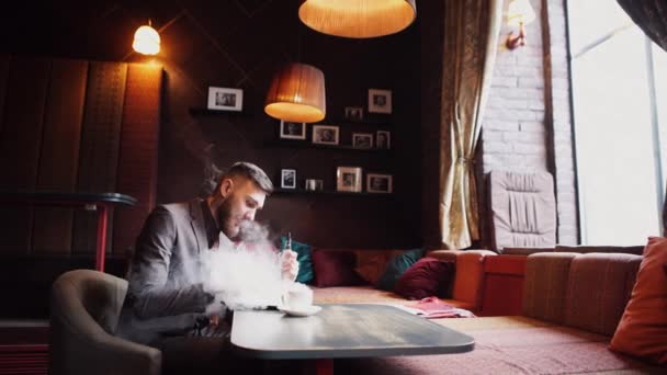 Hombre usando un avanzado e-cigarrillo personal y tableta usada — Vídeo de stock