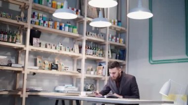 Tablo oturan ve bir telefon kullanarak inek hipster adam