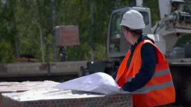 Bir şantiye planları bakarak mimar