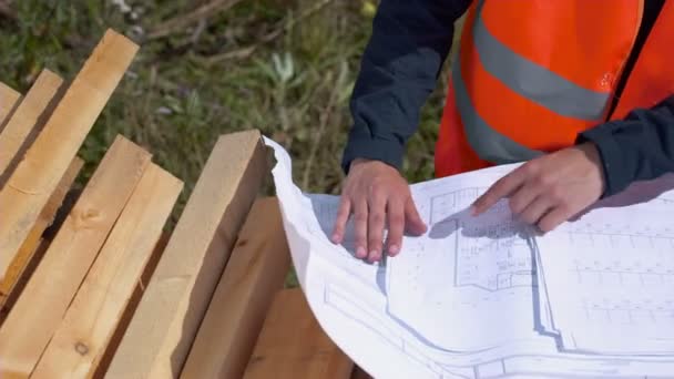 Arquiteto olhando para plantas em um canteiro de obras — Vídeo de Stock