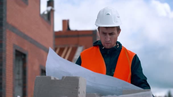 Architect kijken naar blauwdrukken in een bouwterrein — Stockvideo