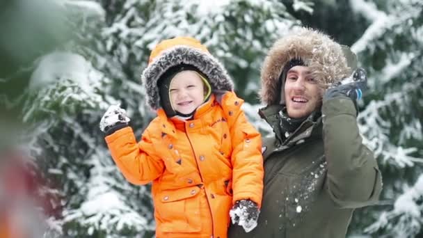 Atractiva familia de tres personas divirtiéndose en un parque invernal de nieve — Vídeo de stock