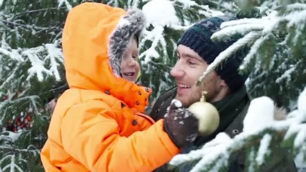 Atractiva familia de tres personas divirtiéndose en un parque invernal de nieve — Vídeo de stock