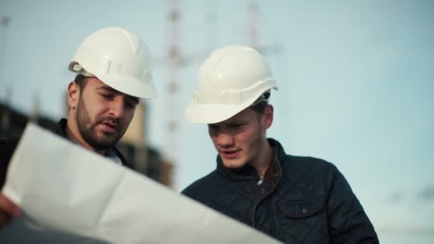 Engenheiro e cliente olhando para o projeto no canteiro de obras — Vídeo de Stock