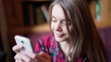 Sonra uzun yolculuk için tasarlanmıştır. Hareket eden telefon tutarak ve gülümseyen yerde yatarken şapkalar içinde güzel genç kadın Üstten Görünüm