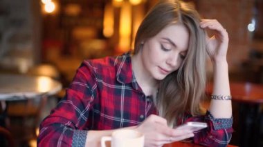 Sonra uzun yolculuk için tasarlanmıştır. Hareket eden telefon tutarak ve gülümseyen yerde yatarken şapkalar içinde güzel genç kadın Üstten Görünüm