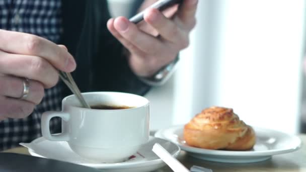 Чоловік використовує мобільний смартфон з кавою на відкритому повітрі . — стокове відео