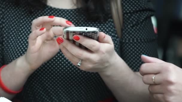 Mujer joven sonriendo y mensajes de texto en su teléfono móvil — Vídeos de Stock