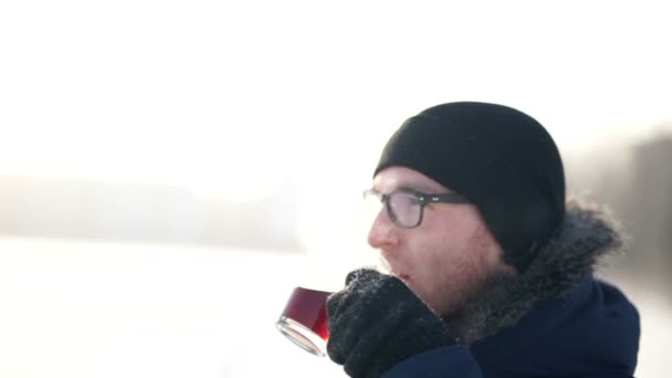 Jeune homme buvant du café chaud à l'extérieur dans la journée froide d'hiver — Video