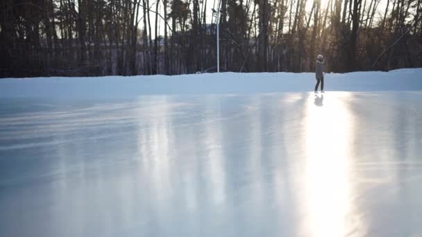 Jeune femme patinant sur glace avec des patins artistiques à l'extérieur dans la neige — Video
