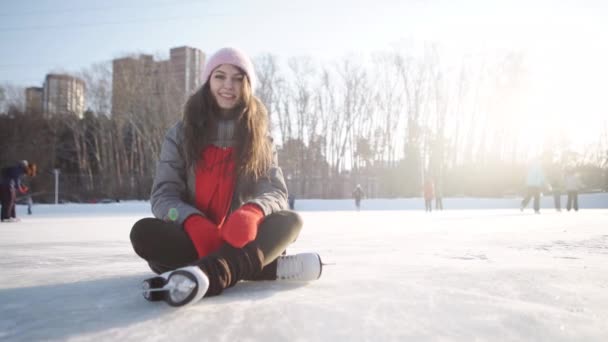 Joven mujer cayó en pista de patinaje y sosteniendo su rodilla — Vídeo de stock