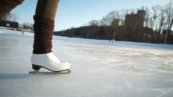 Mujer joven patinando sobre hielo con patines de figuras al aire libre en la nieve — Vídeos de Stock