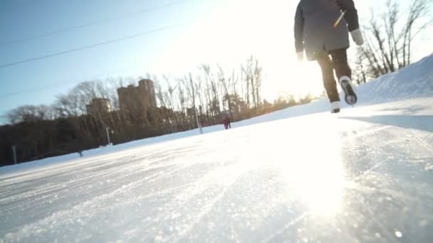 若い女性の図が付いている氷の上でスケートが雪の中で屋外スケートします。 — ストック動画