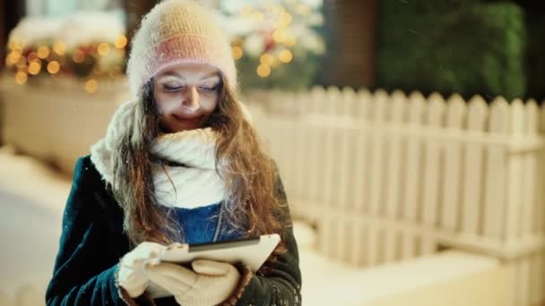 Mujer de invierno con tableta afuera en la nieve — Vídeos de Stock