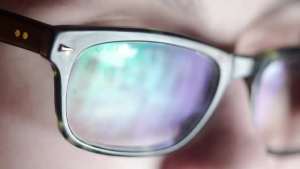 Closeup shot of boy in glasses surfing internet at night — Stock Video