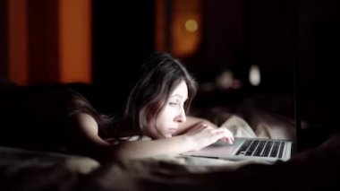 mutlu genç kadın yatakta yatarken laptop ile. beyaz izole