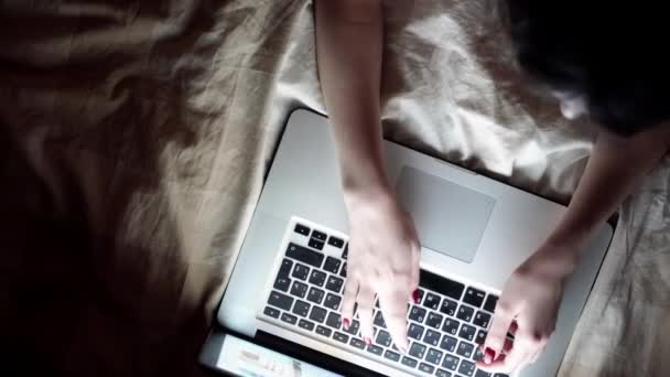 Ευτυχής νεαρή γυναίκα με φορητό υπολογιστή που βρίσκεται στο κρεβάτι. απομονωθεί σε λευκό — Αρχείο Βίντεο