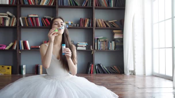 Femme ludique soufflant des bulles de fête à la caméra — Video