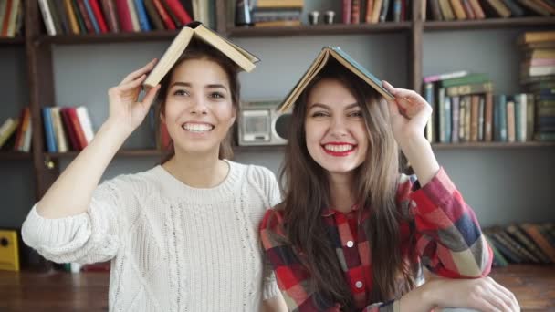 Twee vrouwelijke vrienden bekijkt tijdschrift op bed thuis. — Stockvideo