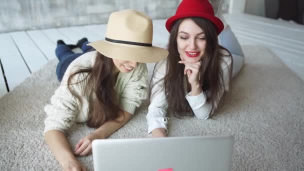 Duas meninas bonitas olham o computador portátil no café de verão — Vídeo de Stock