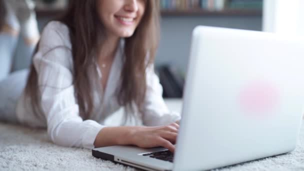 Mujer hermosa joven feliz usando el ordenador portátil, en interiores — Vídeo de stock
