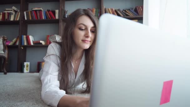 Mujer hermosa joven feliz usando el ordenador portátil, en interiores — Vídeos de Stock