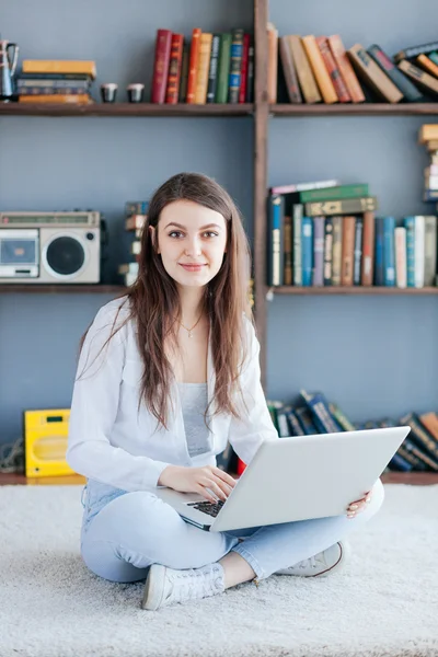 Ευτυχισμένη νεαρή γυναίκα που χρησιμοποιεί φορητό υπολογιστή στο σπίτι — Φωτογραφία Αρχείου