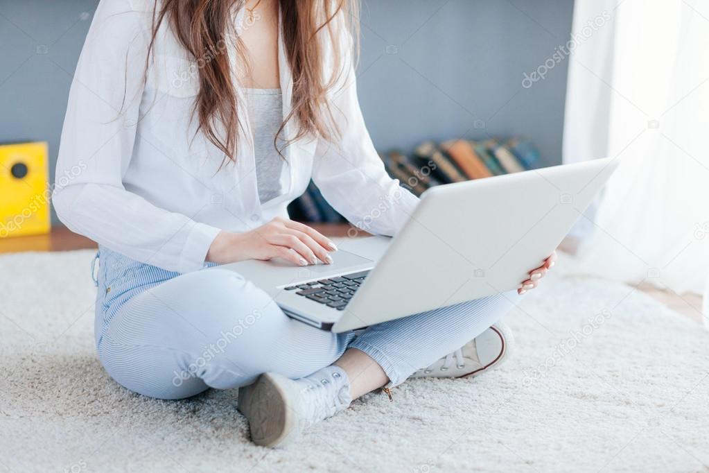 Happy young woman using laptop at home