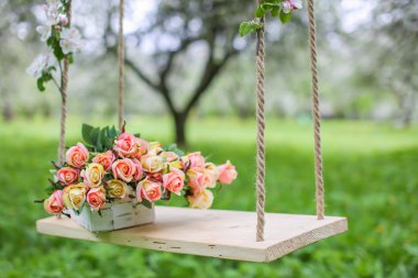 bir buket gül bahçesinde bir salıncak üzerinde