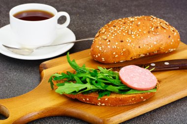 Sandviç salam, öğrenciyle kahvaltı için roka ve