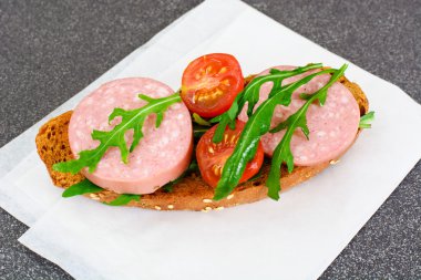 Sandviç salam, öğrenciyle kahvaltı için roka ve