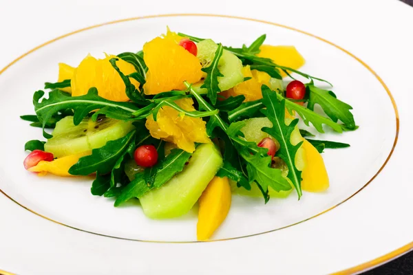 Färsk mango, rucola, kiwi, apelsin och granatäpple. — Stockfoto