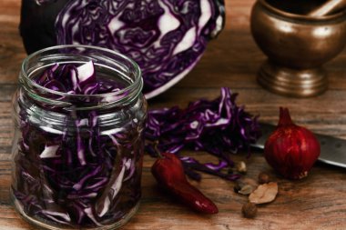 Bıçak ile ahşap arka plan üzerinde kırmızı lahana.